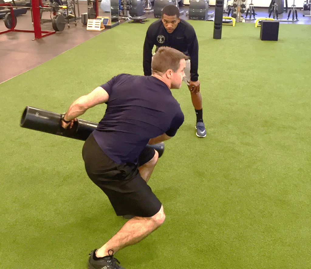 A male personal trainer coaching a male athlete inside a 1TO1 Fitness facility
