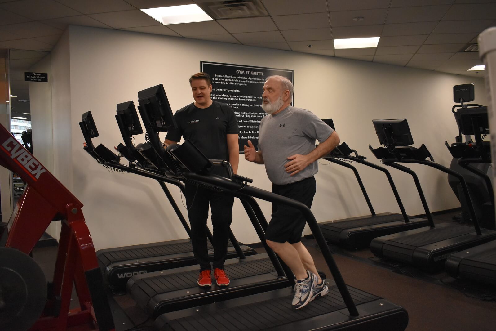 A man in a gray shirt runs on a treadmill, a common type of zone 2 cardio
