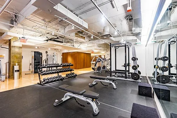 An open gym floor with weight racks and benches